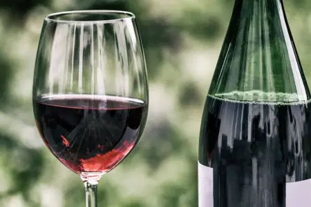 Rotwein in Weinglas neben Weinflasche